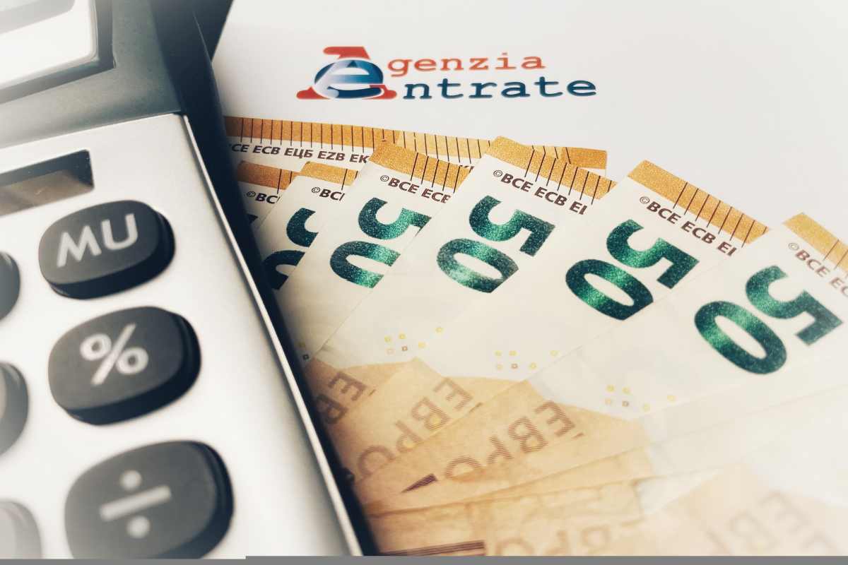 Letter from the revenue agency (agenzia delle entrate) with a calcultator and fifty euro banknotes . Concept of Italian Taxes .